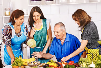 caregivers preparing meal with a senior man