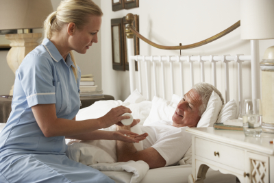 caregiver giving medication to senior man
